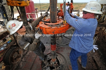 Noe Olvera, left, and Kevin Giddings, right, add a section of casing down a vertical well on the floor of Trinidad Rig 433 on Wednesday, Nov. 2, 2016, in Midland County. James Durbin/Reporter-Telegram